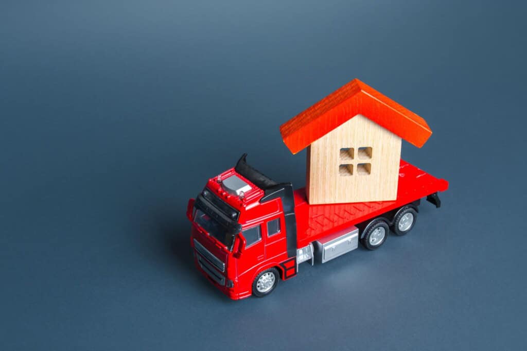 A red toy truck transporting a house