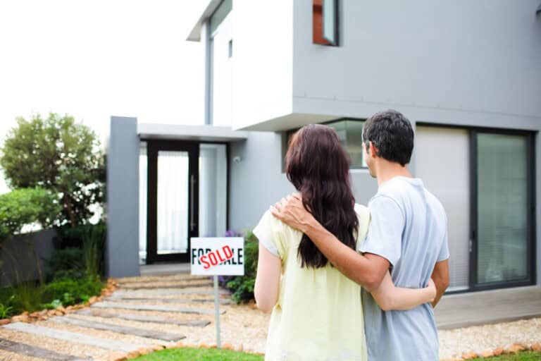 Newlyweds in front of their new home