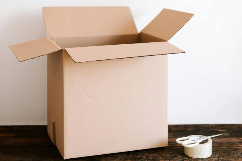 A carton, pair of scissors, and packing tape in preparation for moving